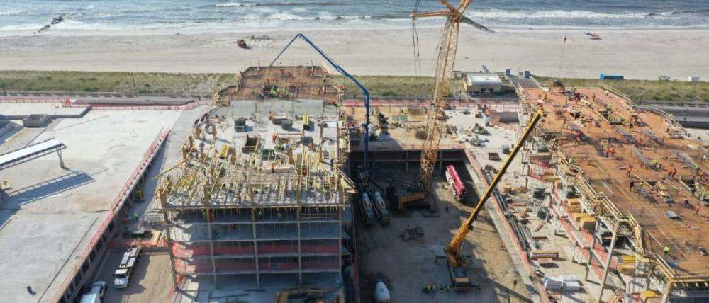 Crews placing concrete on the top deck, boom pump and mixers staged below