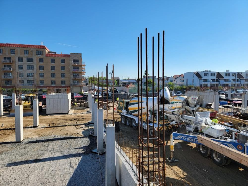 Column rebar cages and foundation walls with a Nicolia mixer and pump on site