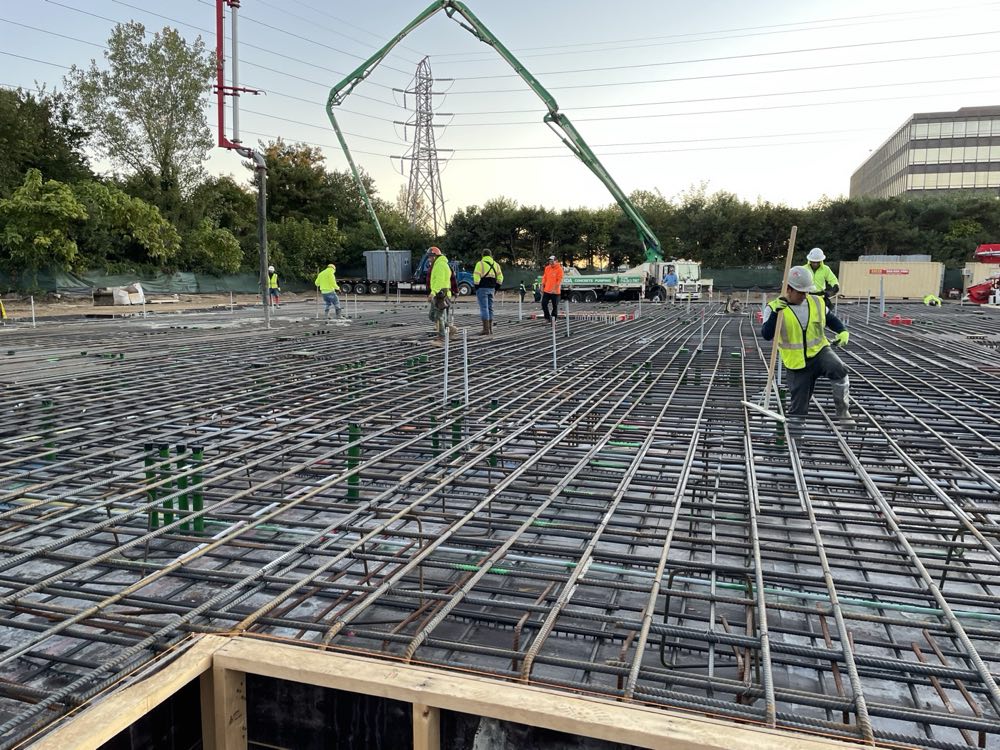 Crew placing and finishing a large reinforced deck pour at dusk