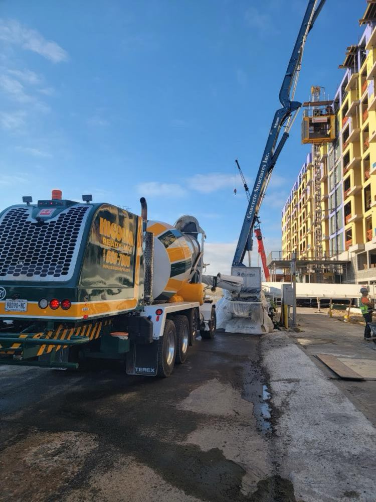 Nicolia front-discharge mixer feeding a concrete pump at a mid-rise residential building