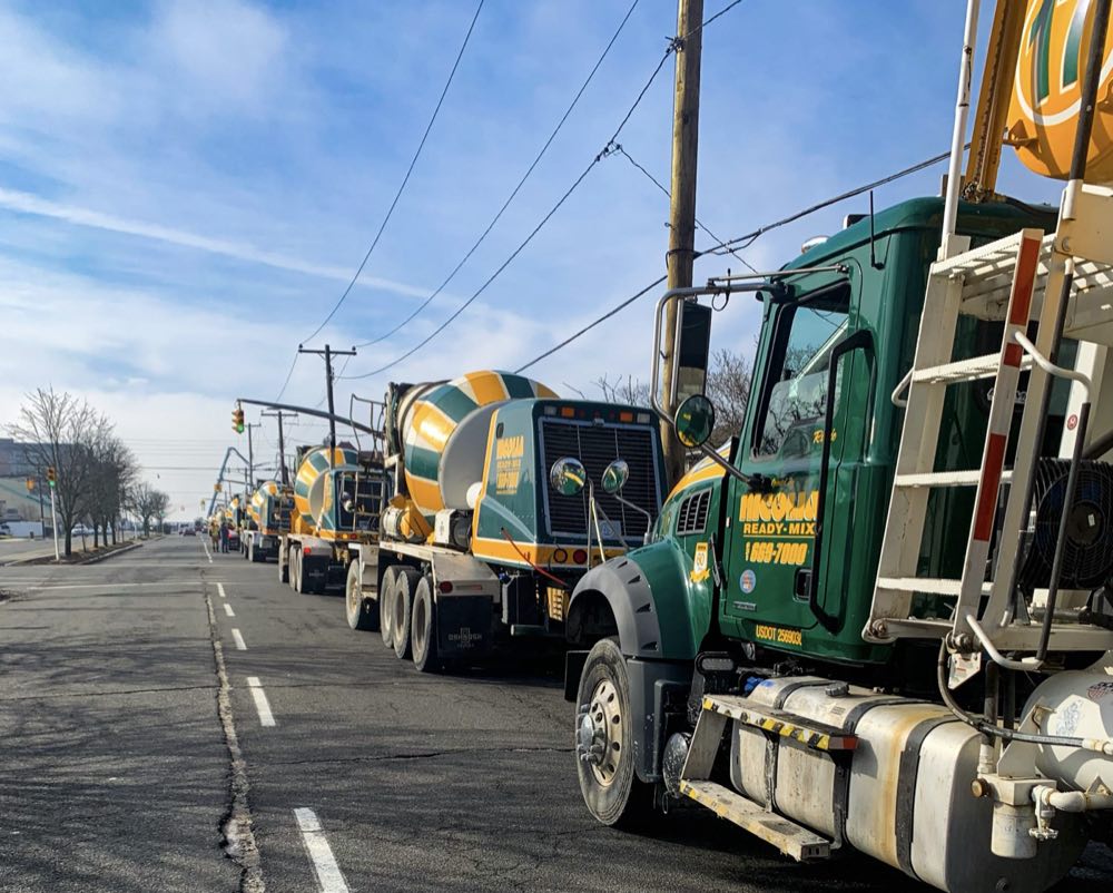 Line of Nicolia Ready-Mix mixer trucks on the road