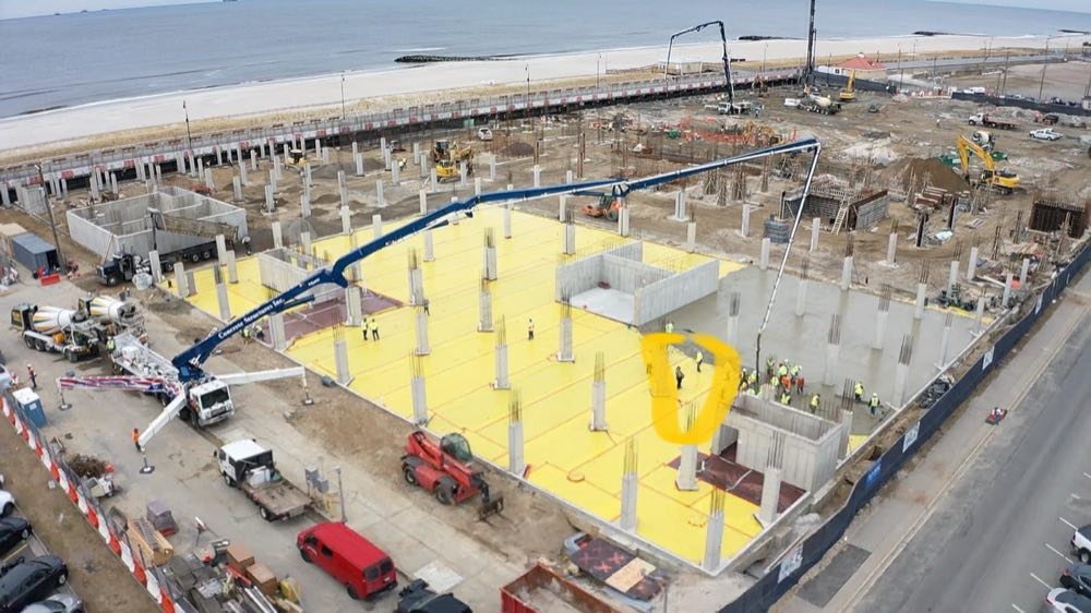 Aerial view of a large podium foundation with a concrete pump placing