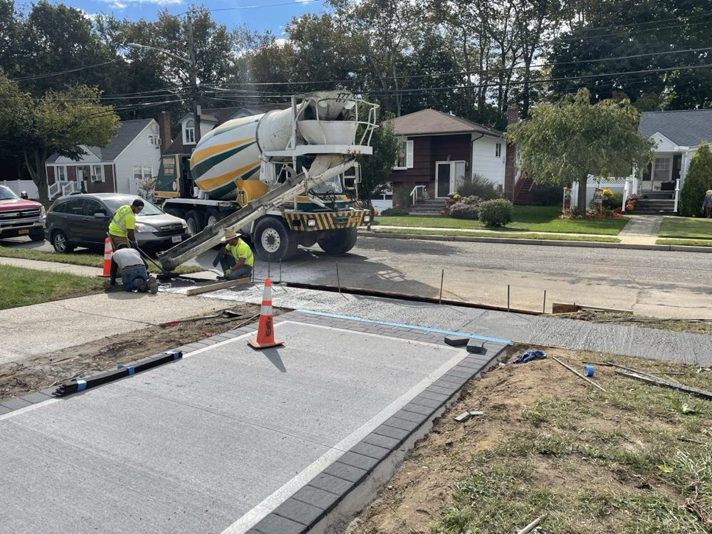 Nicolia mixer discharging down a chute for a residential driveway pour on a Long Island street